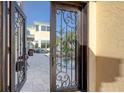 A detailed wrought iron door opens to a lush outdoor pool and patio entertainment area at 3628 Fair Oaks Pl, Longboat Key, FL 34228