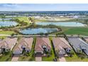 Aerial view of houses next to a golf course with ponds and beautiful greenery around at 3860 Santa Caterina Blvd, Bradenton, FL 34211