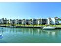 Condo exterior featuring private boat docks, lush landscaping, and a tranquil waterfront setting at 448 Gulf Of Mexico Dr # A204, Longboat Key, FL 34228