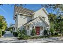 A beautiful two-story home showcases its bright exterior, striking red door, and lush, mature landscaping at 515 S Osprey Ave, Sarasota, FL 34236