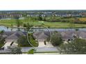 An aerial view of a home near a lake, a golf course, and other homes at 5276 Mahogany Run Ave, Sarasota, FL 34241