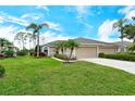 Charming single Gathering home featuring a lush lawn and mature landscaping including palm trees and manicured shrubs at 5276 Mahogany Run Ave, Sarasota, FL 34241