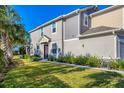 Neutral painted townhome with lush landscaping and a covered front entry on a sunny day at 5580 Pleasantview Ct, Lakewood Ranch, FL 34211