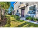 Neutral painted townhome with lush landscaping and a covered front entry on a sunny day at 5580 Pleasantview Ct, Lakewood Ranch, FL 34211