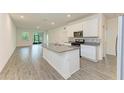 Modern kitchen with white cabinets, gray countertops, and island at 5866 Bungalow Grove Ct, Palmetto, FL 34221