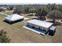 Aerial view of two metal roofed residential buildings on a sprawling property with mature trees at 6521 121 St E Ave, Parrish, FL 34219