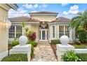 Inviting entrance with elegant landscaping and a tiled roof at 7327 Kensington Ct, University Park, FL 34201