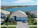 Single-Gathering home with a lake view, gray roof, and two-car garage at 8063 Waterbend Trl, Sarasota, FL 34240