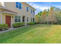 Beautiful townhome with a red front door, well-kept lawn, and lovely, mature landscaping at 8362 Enclave Way # 103, Sarasota, FL 34243