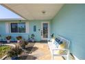 Inviting front porch with seating and decorative plants, offering a warm welcome to the home at 1956 Greenlawn Dr, Englewood, FL 34223