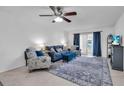 Living room features comfortable seating, a ceiling fan, and sliding glass doors leading to a balcony at 3050 Lake Bayshore Dr # O-108, Bradenton, FL 34205