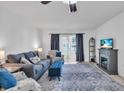 Cozy living room with gray sofa, patterned armchairs, fireplace, and sliding glass doors at 3050 Lake Bayshore Dr # O-108, Bradenton, FL 34205