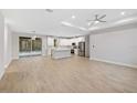 Open-concept living space with wood-look tile, seamlessly flowing into a modern kitchen and pool access at 336 Milford St, Port Charlotte, FL 33953