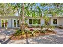 Exterior view of home featuring a paver driveway and tropical landscaping at 3705 Tangier Ter, Sarasota, FL 34239