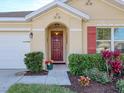 Front entrance with red door and nicely landscaped area at 431 Gris Sky Ln, Bradenton, FL 34212