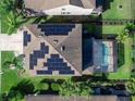 An aerial view of a home with solar panels on the roof and a screened-in pool in the backyard at 4617 Garden Arbor Way, Bradenton, FL 34203