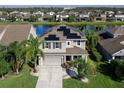 Aerial view of a home with solar panels, a two car garage, and backyard with lake view at 4617 Garden Arbor Way, Bradenton, FL 34203