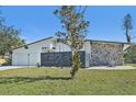 Landscaped front yard featuring a modern white facade and stone accents on a charming single-story home at 494 E Shade Dr, Venice, FL 34293