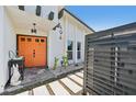 Inviting entrance with a vibrant orange double front door and modern architectural details at 494 E Shade Dr, Venice, FL 34293