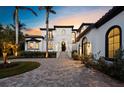 Elegant two-story estate with a manicured lawn, grand entrance, and beautiful architectural features at 500 Harbor Point Rd, Longboat Key, FL 34228