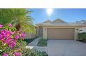 Inviting home with a two-car garage and beautiful flowers and landscaping at 5116 Timber Chase Way, Sarasota, FL 34238