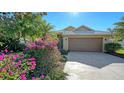 Lovely home with lush landscaping, featuring colorful flowers and a well-manicured lawn at 5116 Timber Chase Way, Sarasota, FL 34238