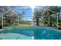 Screened-in pool offers stunning views of the lake and surrounding lush greenery at 5116 Timber Chase Way, Sarasota, FL 34238