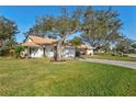 Well-manicured lawn and landscaping accent this single-story home with a brick driveway and a tile roof at 5718 Garden Lakes Palm, Bradenton, FL 34203