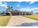 Inviting single-story home showcasing a paved driveway leading to an attached two-car garage at 6001 Firefly Ln, Apollo Beach, FL 33572