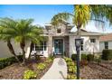 Home's entry featuring a stone facade, turquoise front door, and lush tropical landscaping at 6373 Royal Tern Cir, Lakewood Ranch, FL 34202