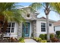 The home's charming front entrance with stone accents and colorful landscaping details at 6373 Royal Tern Cir, Bradenton, FL 34202