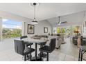 Bright dining area with a modern table, chairs, and large windows overlooking the lush greenery at 6796 Gasparilla Pines Blvd # 45, Englewood, FL 34224