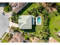 An aerial view shows the house with a private pool, fenced backyard, and mature trees at 6807 46Th E Ter, Bradenton, FL 34203