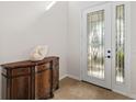 A decorative glass front door and tiled entryway, next to a wood console table at 6807 46Th E Ter, Bradenton, FL 34203