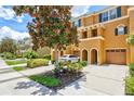 Three story townhome with a two-car garage and a magnolia tree at 7350 Black Walnut Way, Lakewood Ranch, FL 34202