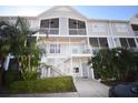 Condo building with stairs, balconies, and tropical landscaping at 850 S Tamiami Trl # 724, Sarasota, FL 34236