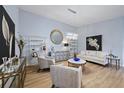 Elegant living room with light blue walls, wood floors, modern furniture, and stylish decor at 8849 Etera Dr, Sarasota, FL 34238