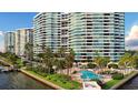 Luxury waterfront condominium exterior showcases lush landscaping and a serene pool area, perfect for relaxation at 888 Blvd Of The Arts # 1608, Sarasota, FL 34236