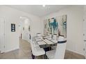 Dining room with modern glass table and white chairs at 8995 Milestone Dr, Sarasota, FL 34238