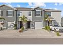 Two-story townhome with gray exterior, two-car garage, and landscaping at 8995 Milestone Dr, Sarasota, FL 34238