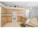 Bright kitchen with granite countertops, tiled floors, pendant lighting and abundant cabinetry for storage at 10726 Old Grove Cir, Bradenton, FL 34212