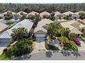 An aerial view of a well-kept neighborhood with lush greenery and similar homes at 1358 Berkshire Ct, Venice, FL 34292