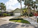 Beautiful home with a two-car garage, tropical landscaping, and a well-maintained lawn at 1358 Berkshire Ct, Venice, FL 34292