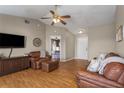 Inviting living room with warm wood floors, ceiling fan, and a cozy seating area with a view to the bedroom at 1406 14Th Street W Ct, Palmetto, FL 34221