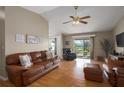 A cozy living room featuring hardwood floors, a ceiling fan, a sliding glass door, and comfortable seating at 1406 14Th Street W Ct, Palmetto, FL 34221