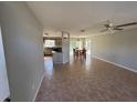 Open floor plan with ceramic tile floors, ceiling fan and view into kitchen and dining area at 18053 Ohara Dr, Port Charlotte, FL 33948