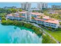 Stunning aerial view of the waterfront condominium complex with lush landscaping and serene turquoise waters at 225 Sands Point Rd # 6204, Longboat Key, FL 34228
