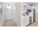 Efficient kitchenette with stainless steel appliances, white cabinets, and a stylish backsplash at 225 Sands Point Rd # 6204, Longboat Key, FL 34228