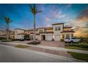 Charming townhome with a well-kept exterior, featuring attached garages and a lovely brick driveway at 23189 Banbury Way # 203, Venice, FL 34293