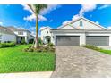 Landscaped front yard with a driveway leading to a two-car garage in front of the house at 2622 Light Sky Ln, Bradenton, FL 34211
